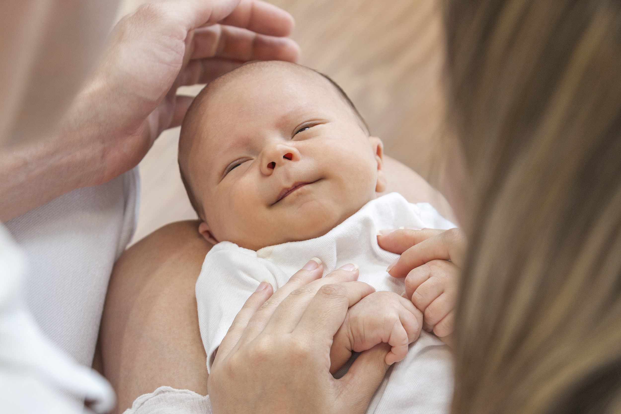 Eltern halten Baby liebevoll im Arm