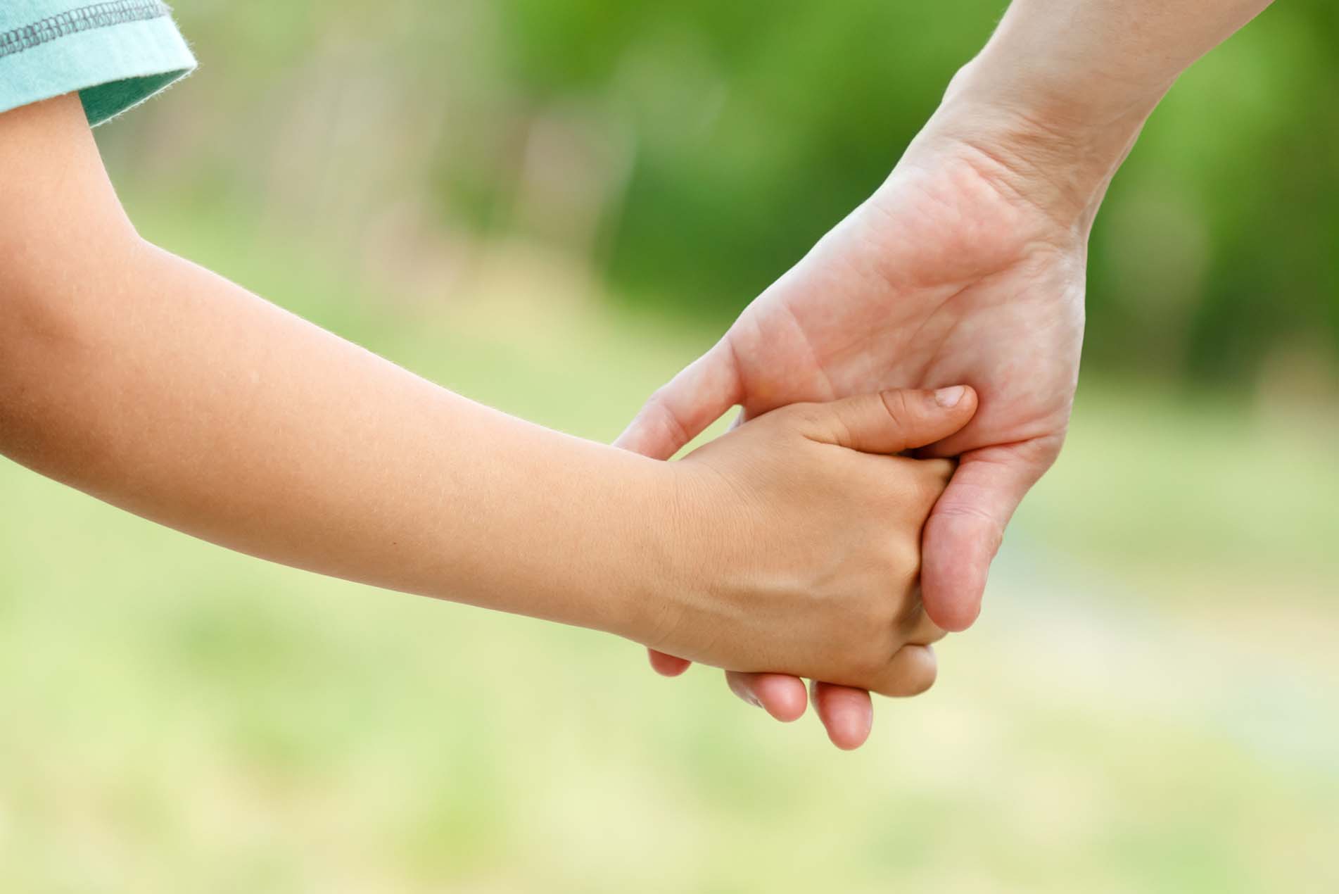 Kind hält die Hand der Mutter